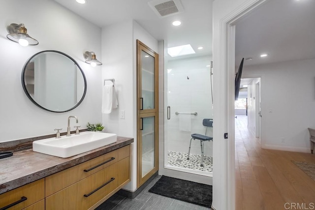 51 Catspaw, Coronado, CA 92118 - bathroom featuring vanity, recessed lighting, a skylight, a stall shower, and wood finished floors