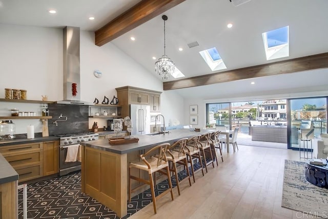 51 Catspaw, Coronado, CA 92118 - kitchen featuring wall chimney exhaust hood, dark countertops, open shelves, high end refrigerator, and gas range