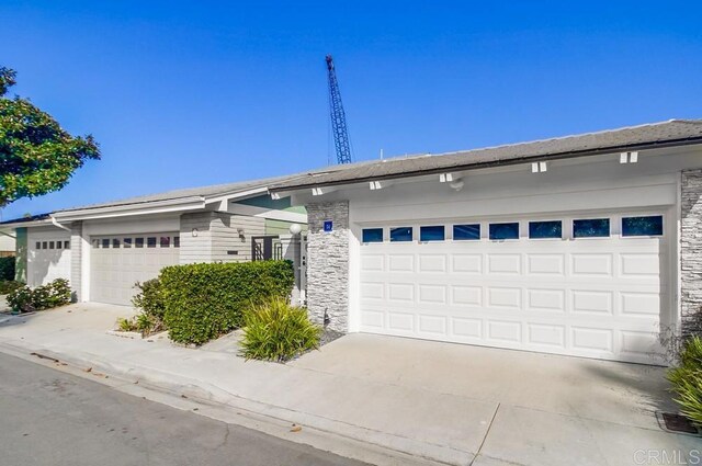 51 Catspaw, Coronado, CA 92118 - view of front of house featuring stone siding, concrete driveway, and a garage