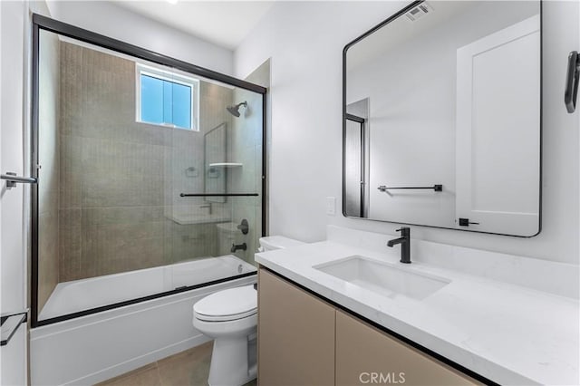 full bathroom with tile patterned floors, vanity, toilet, and shower / bath combination with glass door