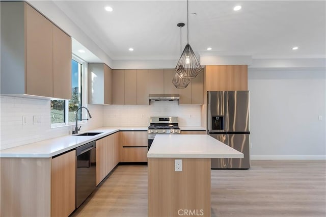 kitchen featuring stainless steel appliances, sink, light brown cabinets, decorative light fixtures, and a kitchen island