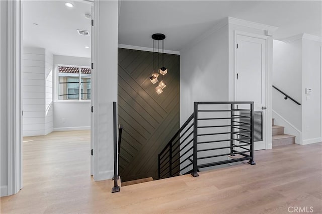 stairway featuring hardwood / wood-style floors and ornamental molding