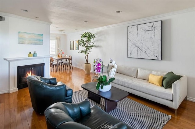 living room featuring hardwood / wood-style flooring and crown molding