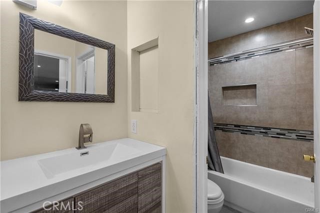 full bathroom featuring vanity, shower / bath combination with curtain, and toilet