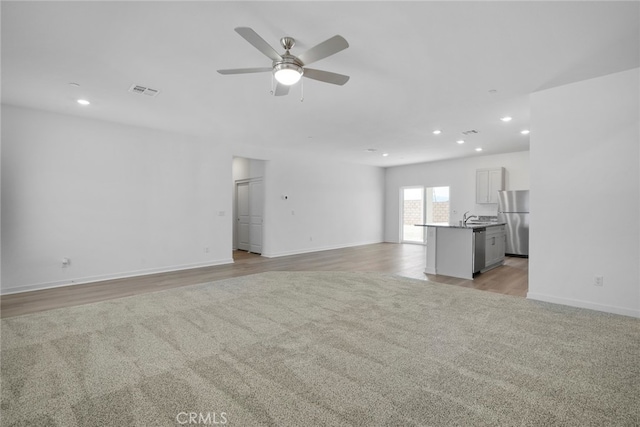 unfurnished living room featuring light hardwood / wood-style floors and ceiling fan