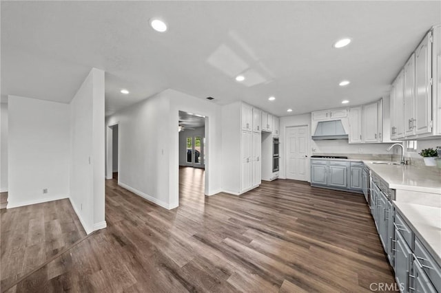 kitchen with gas stovetop, extractor fan, sink, dark hardwood / wood-style floors, and white cabinetry