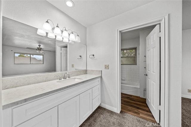 bathroom featuring hardwood / wood-style flooring, ceiling fan,  shower combination, and vanity