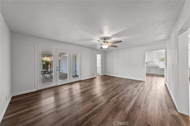 unfurnished living room with french doors, ceiling fan, dark hardwood / wood-style flooring, and a textured ceiling