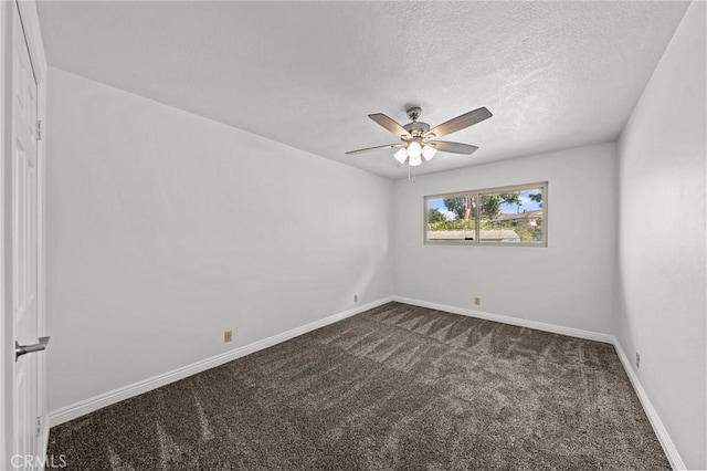 empty room with dark colored carpet, ceiling fan, and a textured ceiling