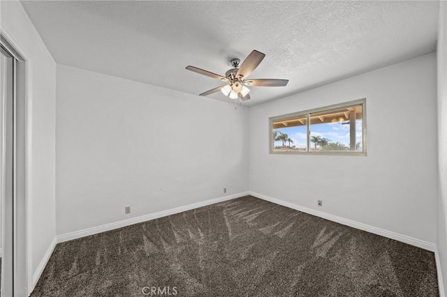 empty room featuring a textured ceiling, dark carpet, and ceiling fan