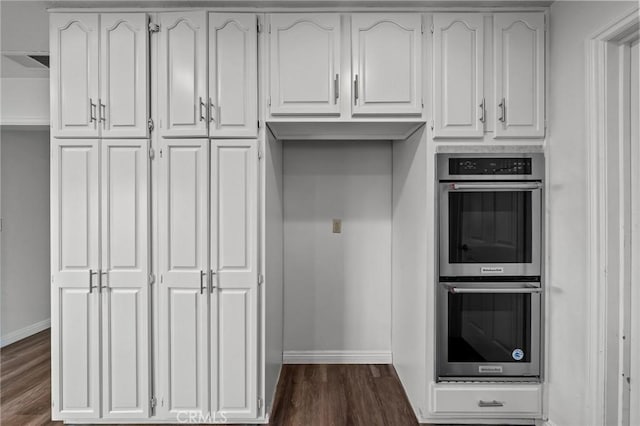 kitchen featuring white cabinets, dark hardwood / wood-style floors, and stainless steel double oven