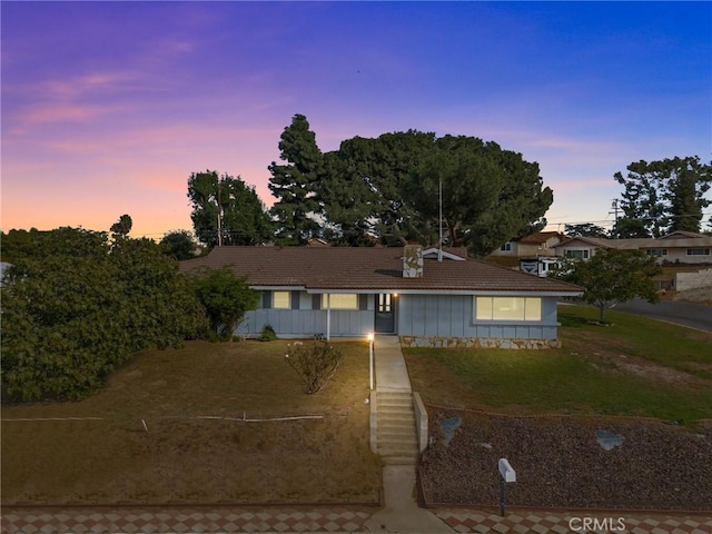 ranch-style home with a yard