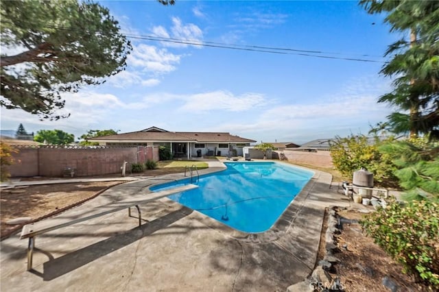 view of pool featuring a diving board and a patio area