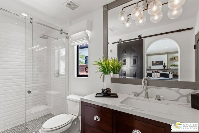 bathroom with toilet, a shower with door, and vanity