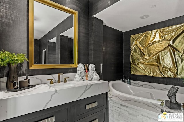 bathroom featuring a relaxing tiled tub and vanity