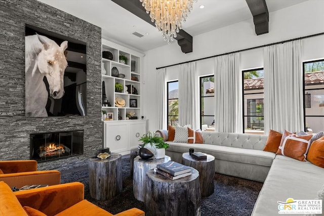 living room featuring built in features, a fireplace, and an inviting chandelier