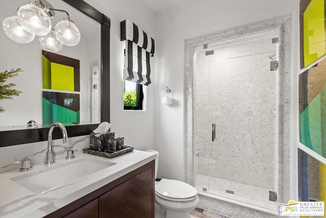 bathroom with toilet, a shower with shower door, and vanity