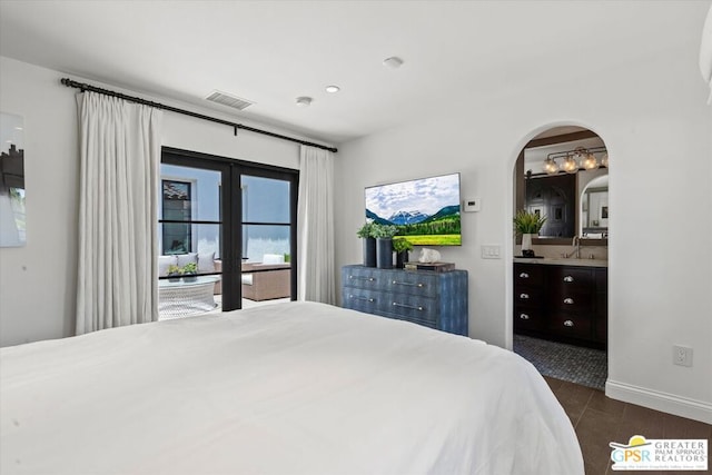 bedroom with access to exterior, sink, dark tile patterned floors, connected bathroom, and french doors