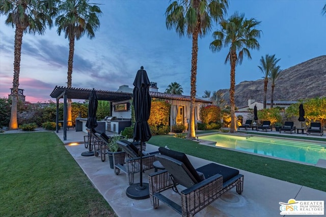 exterior space with a patio area, a mountain view, a pool, an outdoor kitchen, and a pergola