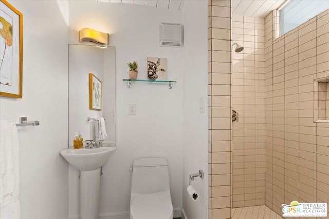 bathroom with toilet and tiled shower