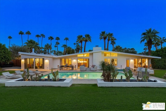 back of house featuring outdoor lounge area, a yard, and a patio