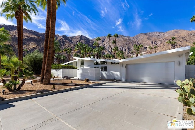 single story home with a garage and a mountain view