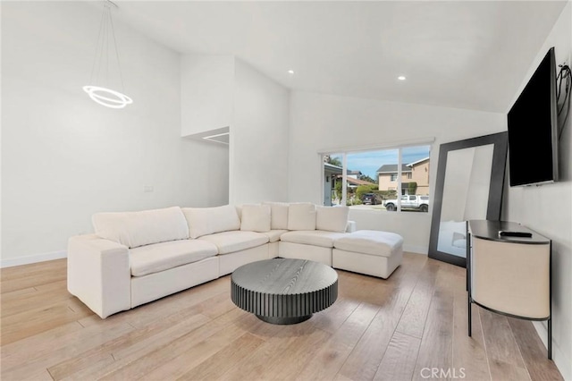 living room featuring light hardwood / wood-style flooring and high vaulted ceiling