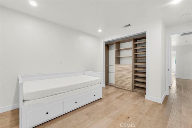 unfurnished bedroom with a closet and light hardwood / wood-style flooring