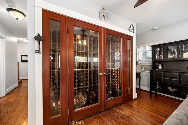 wine area with ceiling fan, baseboards, and wood finished floors