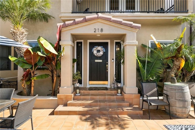 entrance to property featuring a patio area and stucco siding