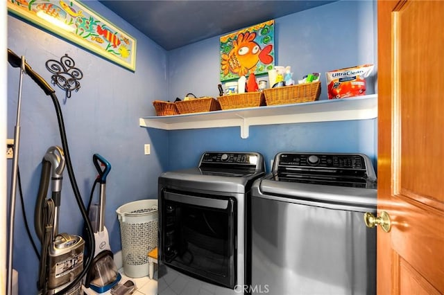 clothes washing area with tile patterned flooring, laundry area, and washer and clothes dryer