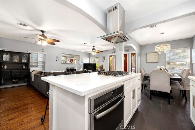 kitchen featuring island range hood, dark hardwood / wood-style floors, hanging light fixtures, stainless steel appliances, and white cabinets