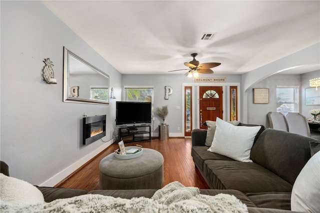 living room featuring ceiling fan and dark hardwood / wood-style floors