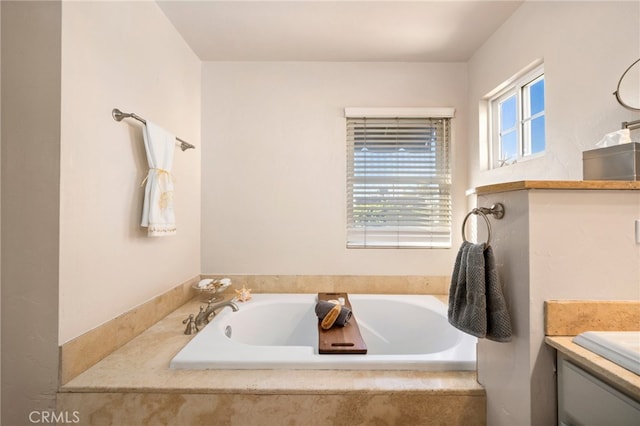 bathroom with vanity and a relaxing tiled tub