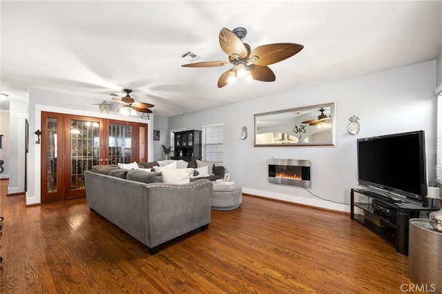 living room featuring dark wood-type flooring and ceiling fan