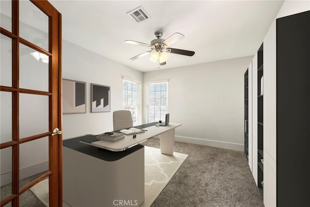 office featuring baseboards, carpet, visible vents, and a ceiling fan