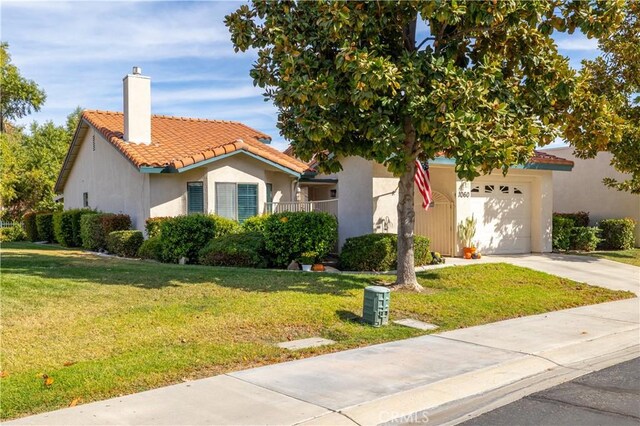 mediterranean / spanish house featuring a front yard and a garage