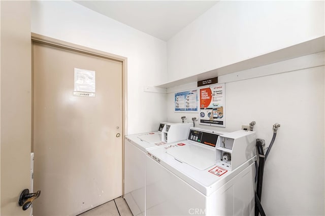 laundry room featuring washing machine and clothes dryer and light tile patterned floors