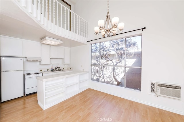 kitchen featuring kitchen peninsula, white cabinetry, light hardwood / wood-style floors, sink, and white appliances