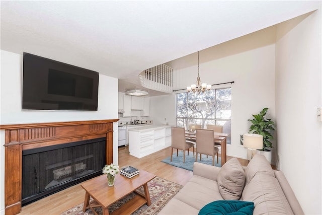 living room with a chandelier and light wood-type flooring