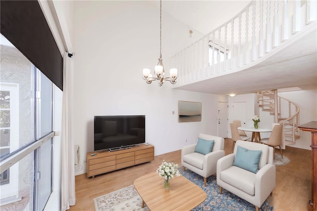 living room featuring a high ceiling, a notable chandelier, and wood-type flooring