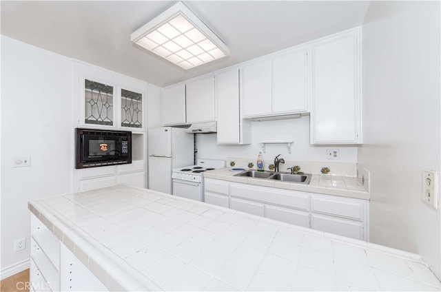 kitchen with tile countertops, sink, white cabinets, and white appliances