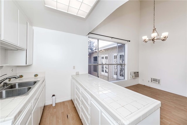 kitchen featuring white cabinetry, light hardwood / wood-style floors, and tile counters