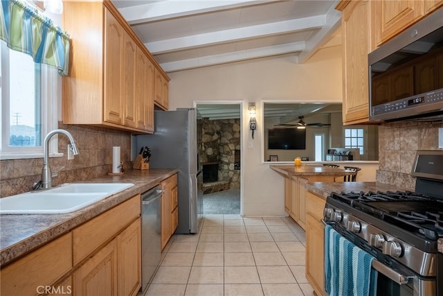 13503 Fidler Ave, Bellflower, CA 90706 - kitchen featuring appliances with stainless steel finishes, backsplash, light tile patterned floors, and a stone fireplace