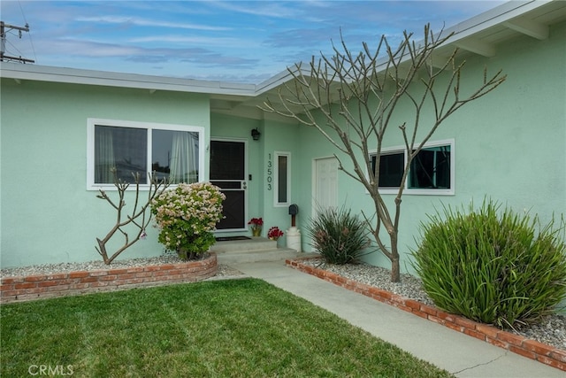 13503 Fidler Ave, Bellflower, CA 90706 - property entrance featuring stucco siding and a lawn