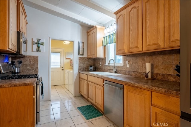13503 Fidler Ave, Bellflower, CA 90706 - kitchen featuring stainless steel appliances, washing machine and clothes dryer, tasteful backsplash, light tile patterned flooring, and dark countertops