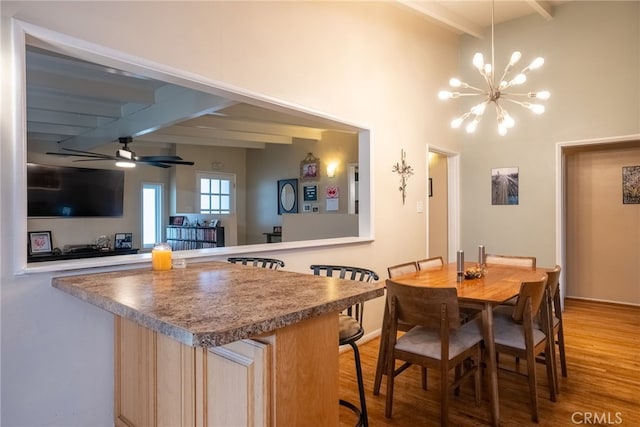 13503 Fidler Ave, Bellflower, CA 90706 - kitchen with beam ceiling, a chandelier, wood finished floors, a ceiling fan, and a kitchen breakfast bar