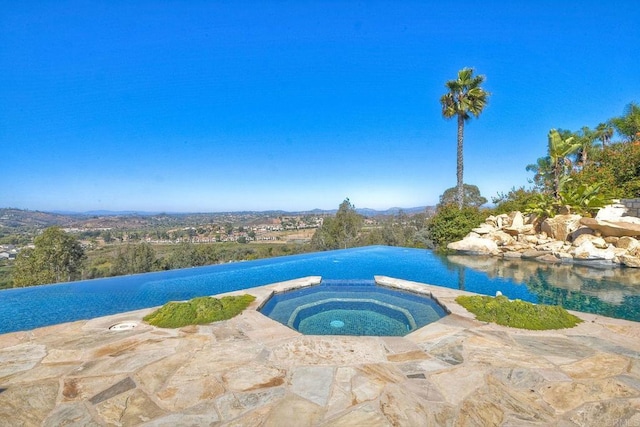 view of swimming pool with an in ground hot tub