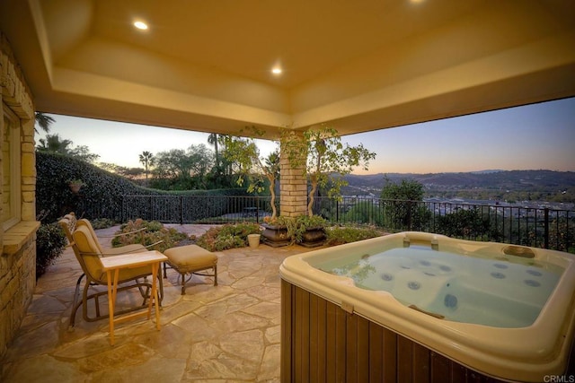 patio terrace at dusk with a mountain view and a hot tub