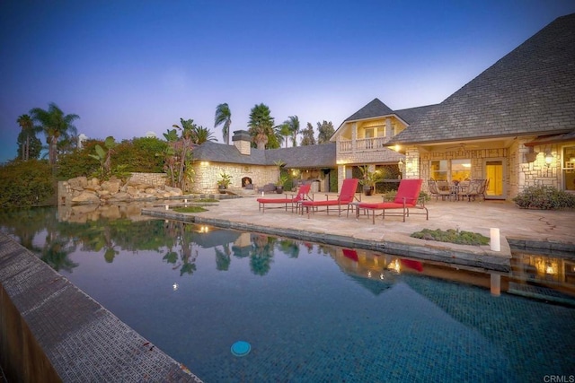 pool at dusk with a patio